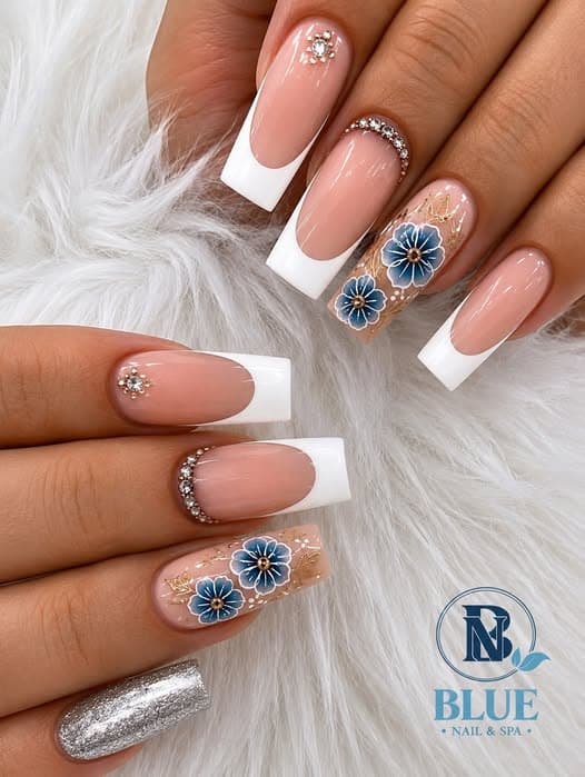 White French tip nails with blue floral art and rhinestones by Blue Nails & Spa, Tallahassee, FL